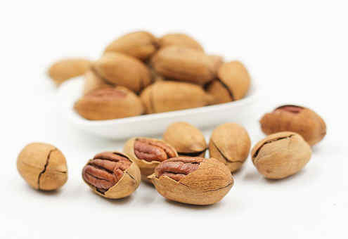 pecans scattered on a white background