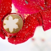 woman in red gloves holding a hot chocolate cocktail with a snowflake marshmallow