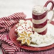 A Hot Chocolate Cocktail with Peppermint Schnapps 2 closeup of The Snuggler, a hot chocolate cocktail in a candy cane striped mug with a candy cane garnish and Christmas cookies on the side