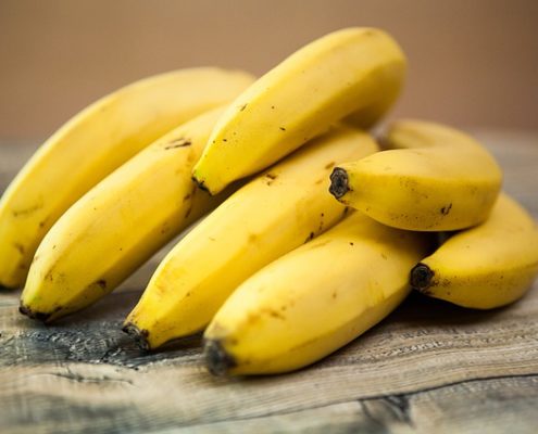 a bunch of bananas on a wooden table