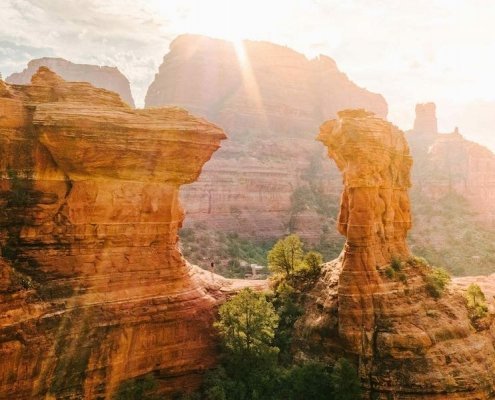 Person hiking in the red rocks near Enchantment Resort shortly after sunrise