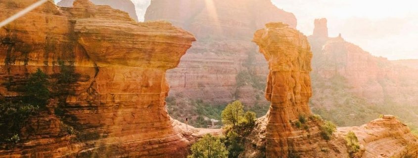 Person hiking in the red rocks near Enchantment Resort shortly after sunrise