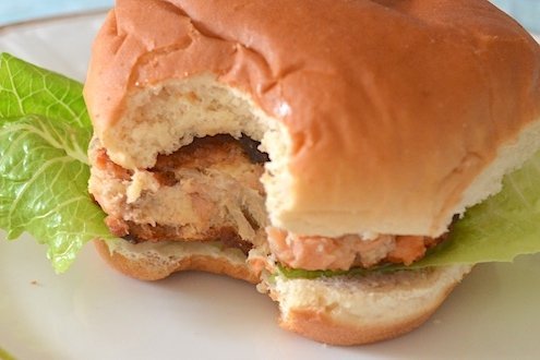Mushroom and Salmon Cakes with White Truffle Mayonnaise 5 closeup of a mushroom and salmon cake with truffle mayonnaise served as a burger with romaine on a white plate