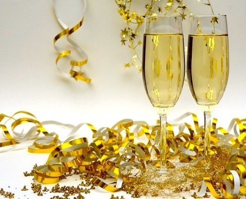 Saffron Fleurtation Champagne cocktails in 2 glasses with gold confetti
