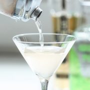 Yazi Mischief - a spicy vodka drink being poured from a shaker into a martini glass