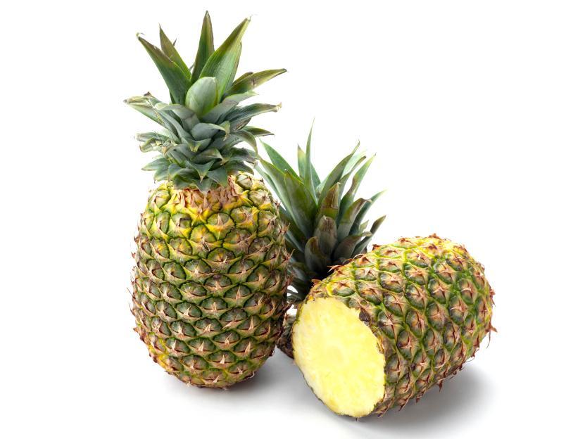 closeup of 2 pineapple, one standing upright, the other laying down with its top cut off