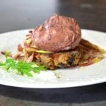 Red Wine Poached Eggs over Black Bean Cakes on a white plate and a black background