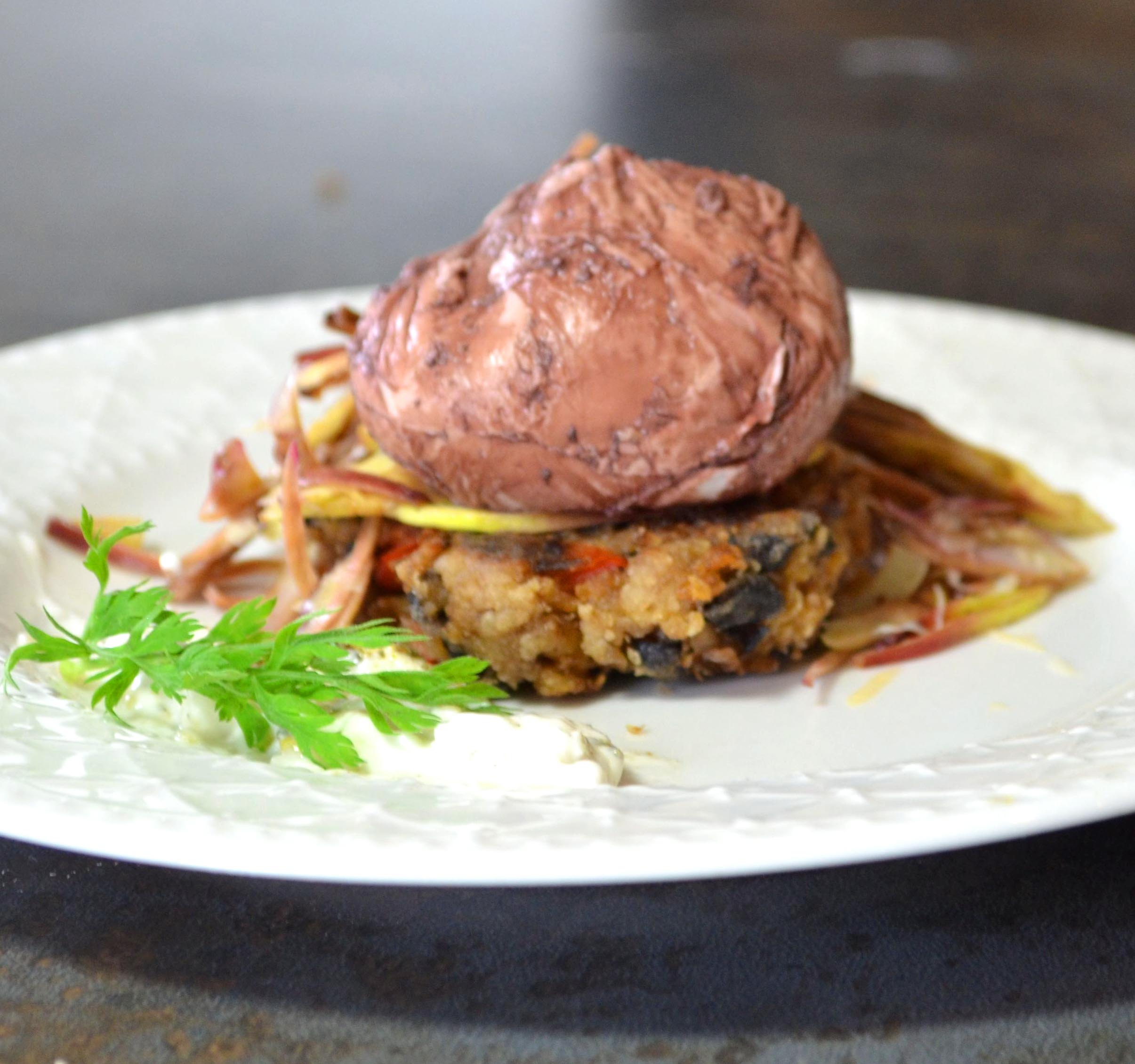 Red Wine Poached Eggs with Oat & Black Bean Cakes & Artichokes 6 Red Wine Poached Eggs over Black Bean Cakes on a white plate and a black background