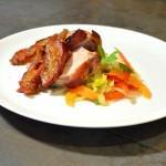 bacon-wrapped pork tenderloin with apricots on a white plate