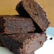 Recipe for Black Bean Chocolate Brownies 3 black bean chocolate brownies on a white plate with a dark yellow background