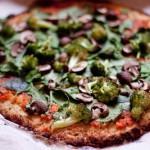 closeup of veggie cauliflower crust pizza on a while background