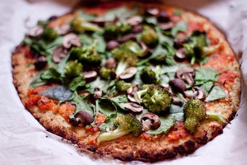 closeup of veggie cauliflower crust pizza on a while background