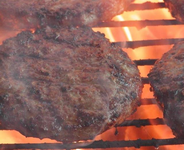buffalo burgers on a grill with flames