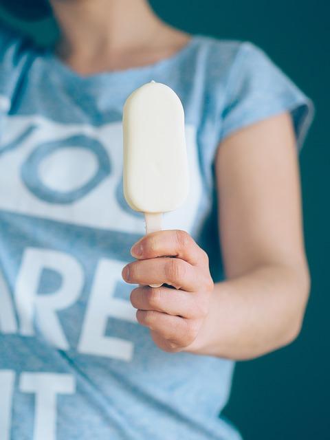 closeup of woman in a blue shirt holding a popsicle