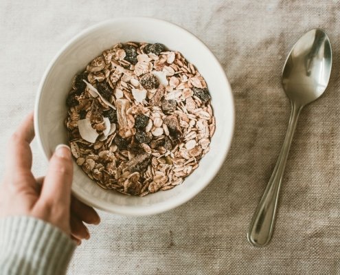 person holding bowl of oatmeal to illustrate the benefits of oats