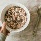 person holding bowl of oatmeal to illustrate the benefits of oats