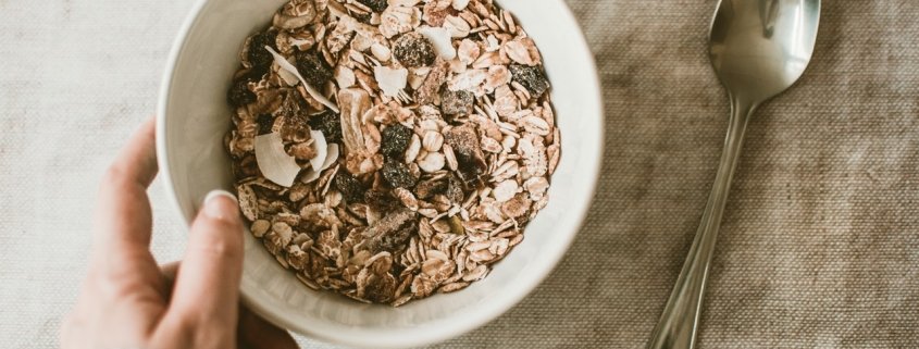 person holding bowl of oatmeal to illustrate the benefits of oats