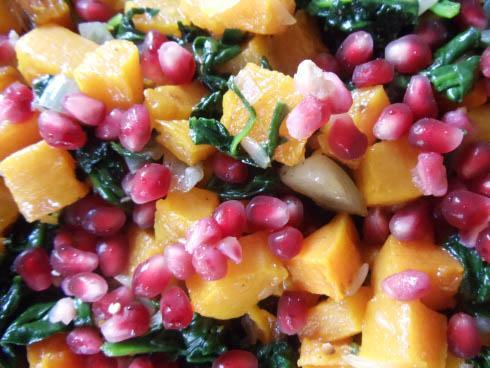 Closeup of Vegan Stuffed Acorn Squash with pomegranate and spinach