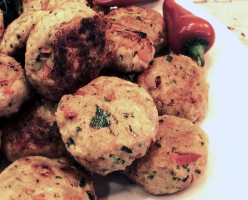 Closeup of spicy fish cakes on a white plate