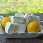 The Best Homemade Lemon Marshmallow Recipe 2 closeup of a pile of lemon marshmallows on a plate with two fresh lemons