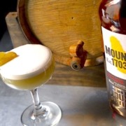 The Monaco: a Crème de Cacao Cocktail 2 creme de cacao cocktail with bottle of Mount Gay Eclipse and a bourbon barrel in the background