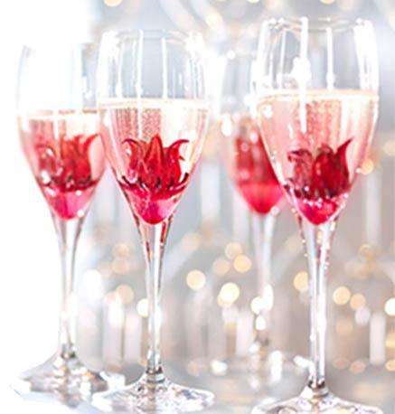 Wild Hibiscus flowers in syrup in glasses of champagne on a white background