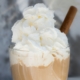 coffee cocktail topped with whipped cream and a cinnamon stick
