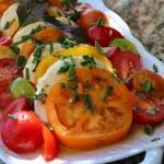 closeup of tomato mozzarella salad on a white serving platter