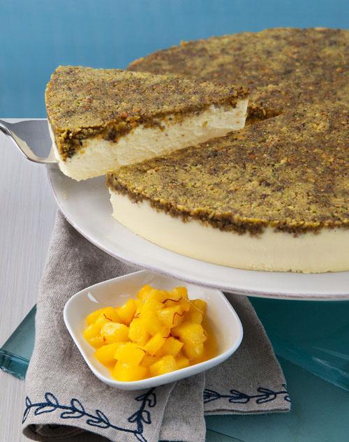 Saffron Cheesecake with Sauteed Pineapple on a cake plate with a dish of pineapple in the foreground