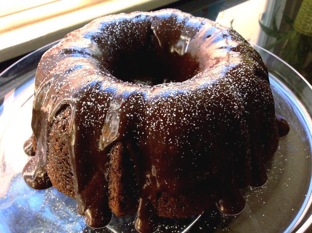 Chocolate Avocado Cake Recipe 7 Chocolate Avocado Cake on a clear plate next to a window