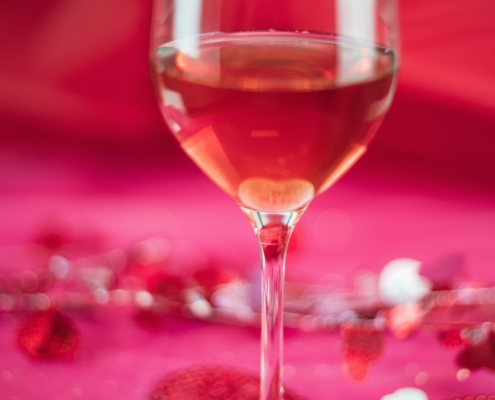 Pink wine on a pink background with valentine confetti