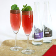 A Romantic Cocktail for Two from DRY Sparkling 2 Dry Sparkling's romantic cocktail served in two flutes, with two bottles of DRY soda sitting behind them