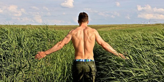 the back of a handsome man walking in a field to illustrate the 10 best foods for men's sexual health