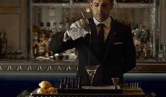 Man holding a martini glass at the Martini Trolley in The Comnaught, knows as the world's best cocktail bar