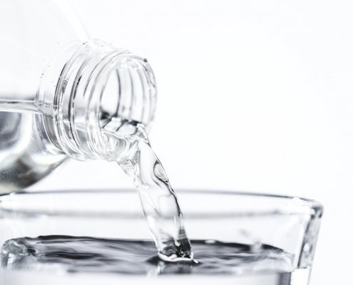 water being poured from a bottle to a glass