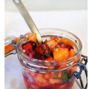 Cranberry Persimmon Fruit Salsa in a small mason jar with a silver spoon sticking out of it