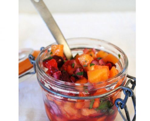 Cranberry Persimmon Fruit Salsa in a small mason jar with a silver spoon sticking out of it