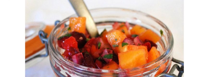 Cranberry Persimmon Fruit Salsa in a small mason jar with a silver spoon sticking out of it