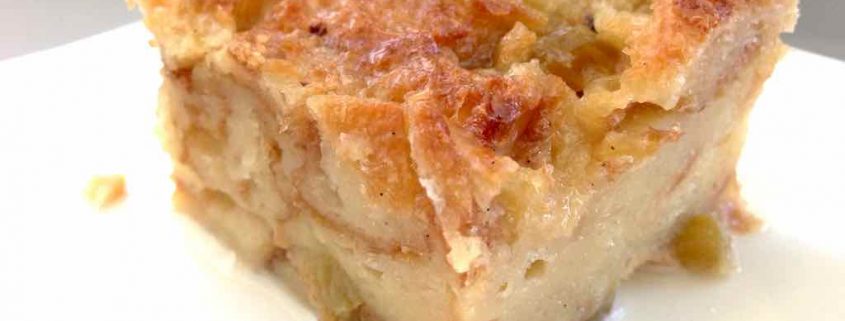 Closeup of Chevre Apple Bread Pudding with Champagne on a White Plate