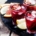 three glasses of red wine citrus sangria on a black tray with wedges of citrus for accents