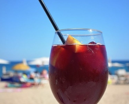 red wine sangria in a wine glass with a black straw