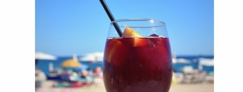 red wine sangria in a wine glass with a black straw