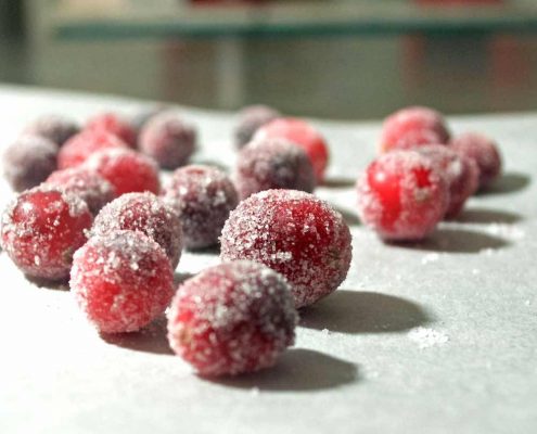 closeup of sugared cranberries on parchment paper