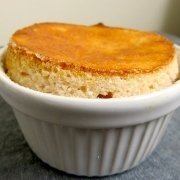 Closeup of Annette's lemon soufflé in a while ramekin on a gray background