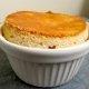 Closeup of Annette's lemon soufflé in a while ramekin on a gray background