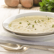 closeup of Irish potato soup in a white bowl with a silver spoon