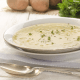 closeup of Irish potato soup in a white bowl with a silver spoon