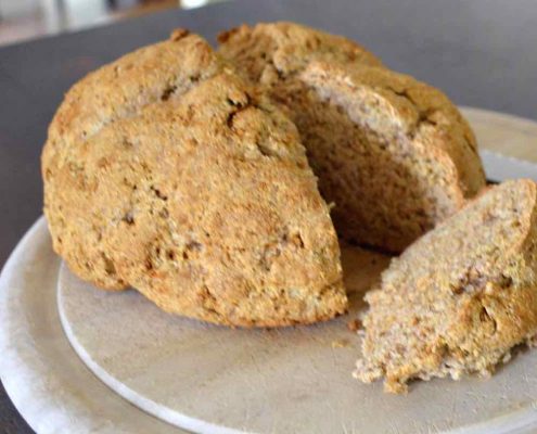 Traditional Irish Soda Bread on a round, wooden cutting board