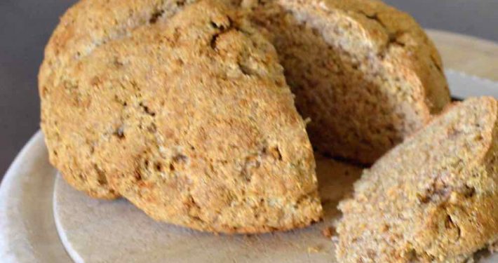 Authentic Irish Brown Bread Recipe (soda bread) 1 Traditional Irish Soda Bread on a round, wooden cutting board