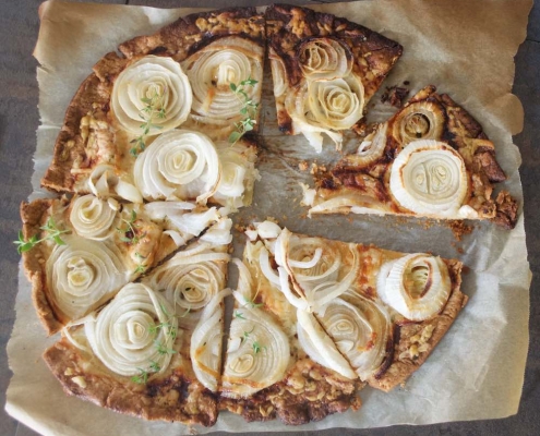 Overhead shot of easy cheese and onion tart on parchment paper